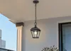 A black outdoor pendant light hangs from a chain on a covered porch. Produktbild-Vorschau
