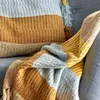 A close-up of a colorful woven blanket draped over a sofa. Produktbild-Vorschau