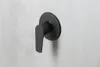 A black matte shower faucet is mounted on a textured gray wall. Anteprima dell’immagine prodotto