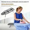 A woman is ironing a blue shirt on a gray ironing board, with a small black ironing board displayed in the background. Produktbild-Vorschau