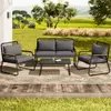 A four-piece outdoor furniture set on a patio with a grassy lawn and trees in the background. Anteprima dell’immagine prodotto