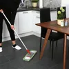 A person is mopping the floor in a kitchen/dining area. Produktbild-Vorschau
