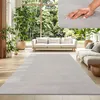 A living room with sofas, plants, and a large rug. Produktbild-Vorschau