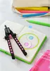 A compass and colored pencils are laid out on a notebook with a yin-yang drawing. Voir les images du produit