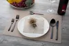 A table setting with a placemat, plate, napkin, cutlery, and a bottle of wine. Náhled obrázku produktu