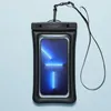 A black waterproof phone pouch with a smartphone inside, shown against a light blue background. Podgląd zdjęcia produktu