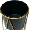 A close-up view of a black planter pot with a gold metal stand. Anteprima dell’immagine prodotto