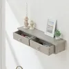 A wall-mounted shelf with two drawers, decorated with a candle, a photo frame, and a small plant. Voir les images du produit