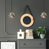A modern living room setting with two pendant lights, a mirror, a dresser, books, and a plant. Podgląd zdjęcia produktu