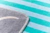 A close-up view of a striped blanket, showing the edge and stitching. Produktbild-Vorschau