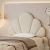 A close-up view of a bed with a shell-shaped headboard and bedding. Voir les images du produit