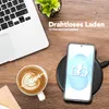 A desk scene with a laptop, coffee, and a smartphone charging wirelessly. Produktbild-Vorschau