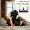 A woman is doing yoga in a room, with a laptop showing a yoga video in the background. Produktbild-Vorschau