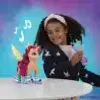 A young girl is playing with a My Little Pony toy that appears to be singing and skating. Produktbild-Vorschau
