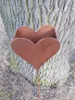A heart-shaped garden stake with a planter attached, stuck in the ground next to a tree. Produktbild-Vorschau