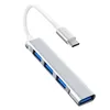 A silver USB C hub with four USB 3.0 ports and a white cable with a USB C connector, isolated on a white background. Produktbild-Vorschau