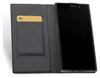 A black Sony smartphone is shown in an open gray flip case with a gold card in a slot. Podgląd zdjęcia produktu