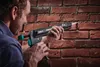 A man is using a caulking gun to apply sealant to a brick wall. Náhled obrázku produktu