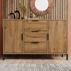 A wooden sideboard with three drawers and two doors, decorated with a mirror and vases on top, set against a wooden slatted wall. Anteprima dell’immagine prodotto