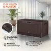 A brown storage box with a rattan-like texture is shown in a modern interior setting with plants and large windows. Podgląd zdjęcia produktu
