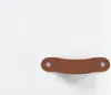 A brown leather handle with two silver rivets is shown against a white background. Produktbild-Vorschau
