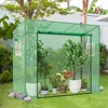 A green greenhouse filled with various potted plants, set up in a garden. Produktbild-Vorschau
