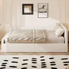 A beige upholstered daybed with a quilted throw and pillows, set in a room with arched wall molding and framed artwork. Anteprima dell’immagine prodotto