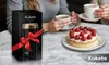 A product shot featuring a coffee grinder next to a cake and two cups of coffee, suggesting a lifestyle context. Podgląd zdjęcia produktu