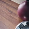 A close-up view of a purple vase and a silver bowl on a wooden surface. Produktbild-Vorschau