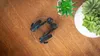 A pair of black and blue headphones are placed on a wooden surface, next to some potted succulents. Produktbild-Vorschau