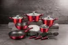 A collection of red cookware and utensils arranged on a gray surface against a dark, textured background. Voir les images du produit