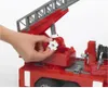 A close-up shot of a person's hand operating a gear on a red toy fire engine ladder. Náhled obrázku produktu