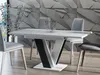 A modern dining room with a white and black high-gloss extendable dining table and four gray chairs, set against a textured gray wall. Náhled obrázku produktu
