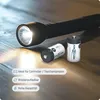 A flashlight is on a wooden surface with two batteries next to it. The flashlight is on and illuminating the area. Produktbild-Vorschau