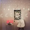 A room decorated with string lights shaped like moons and stars, a framed botanical print, and a decorative tree. Náhľad obrázku produktu