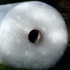 A roll of bubble wrap sitting on grass. Produktbild-Vorschau