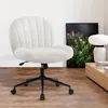 A white, fluffy office chair with a black base and wheels is shown in a room with wooden floors and a framed picture of plants on the wall. Voir les images du produit