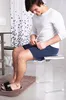 A man is sitting on a clear stool in a bathroom. Produktbild-Vorschau