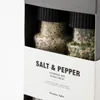 A close-up view of two spice jars, one filled with salt and pepper mix and the other with a herb mix, presented in a gift box. Produktbild-Vorschau