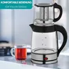 A glass tea kettle with an infuser and a cup of tea on a kitchen counter. Anteprima dell’immagine prodotto
