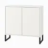 A white cabinet with two doors and black metal legs, shown against a white background. Voir les images du produit