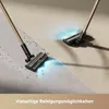 Two vacuum cleaner heads are shown on a floor, one cleaning up debris and the other on a clean surface with blue light illuminating the area. Voir les images du produit