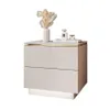 A modern beige nightstand with gold accents and LED lighting, decorated with a vase of dried flowers and perfume bottles. Produktbild-Vorschau