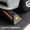 A close-up of a car tire resting on a parking curb with yellow reflective stripes. Náhled obrázku produktu
