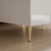 A close-up shot of the bottom corner of a white, high-gloss table with gold legs. Produktbild-Vorschau