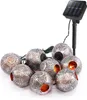 A string of solar-powered decorative lights with eight spherical, intricately patterned lanterns and a solar panel on a stake. Produktbild-Vorschau