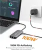 A laptop connected to a USB-C hub, which is then connected to a power adapter plugged into a wall socket. Produktbild-Vorschau