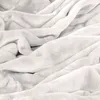 A close-up view of a soft, white, fluffy blanket. Produktbild-Vorschau