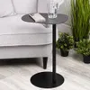 A black metal side table with a phone and glass on it, placed next to a light gray sofa and some potted plants. Voir les images du produit