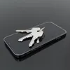 A smartphone with keys on top, set against a dark, reflective background. Podgląd zdjęcia produktu